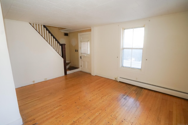 interior space with a baseboard heating unit and hardwood / wood-style floors