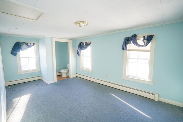 unfurnished bedroom featuring multiple windows, a baseboard heating unit, and ensuite bathroom