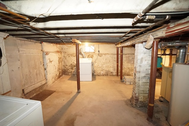 basement with water heater and washer / dryer