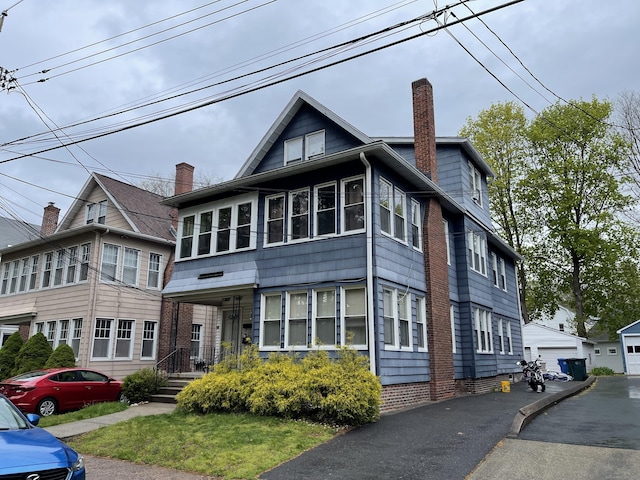 view of front facade featuring a garage and an outbuilding