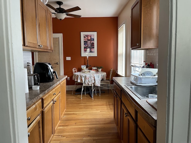 kitchen with backsplash, light wood-type flooring, and ceiling fan