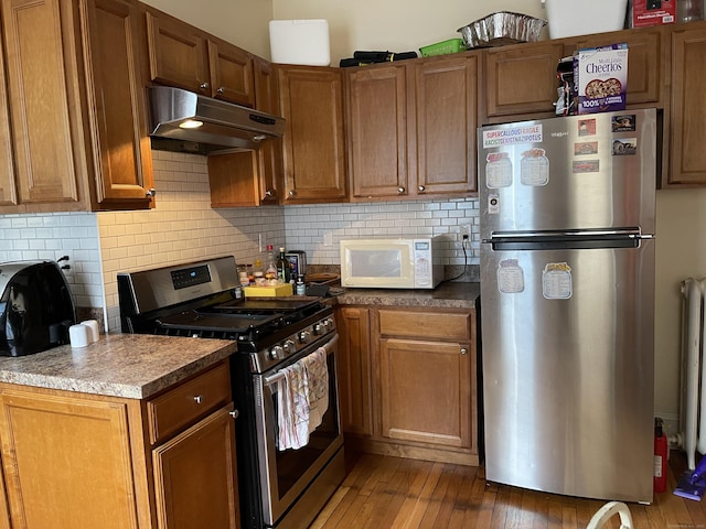 kitchen with decorative backsplash, dark hardwood / wood-style floors, and stainless steel appliances