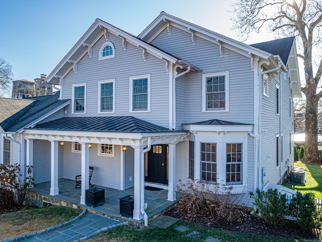 view of front facade with a porch and central AC