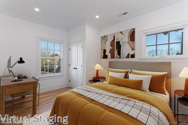 bedroom featuring a closet, light hardwood / wood-style flooring, and crown molding