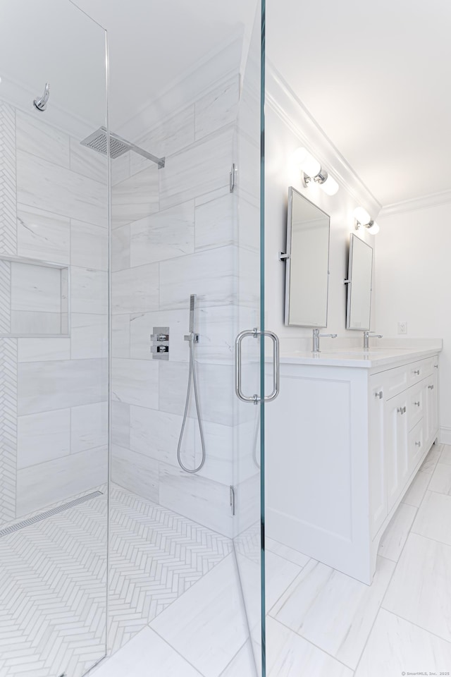 bathroom featuring ornamental molding, a shower with shower door, and vanity