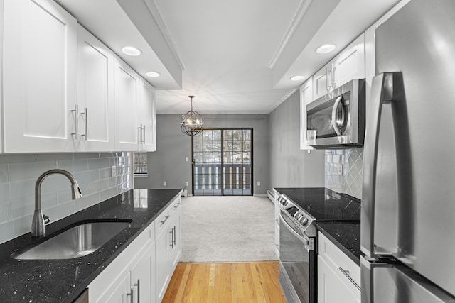 kitchen featuring white cabinetry, sink, decorative backsplash, dark stone counters, and stainless steel appliances