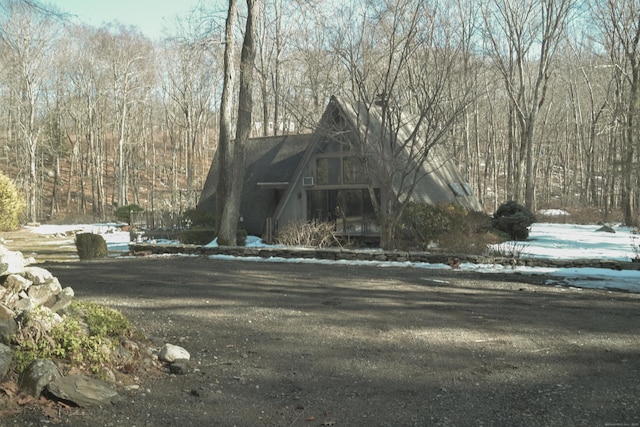 view of front of home with a forest view