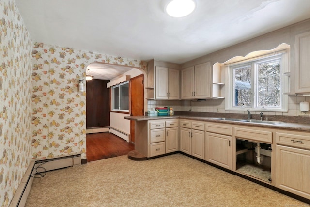 kitchen with sink, light brown cabinetry, and a baseboard heating unit