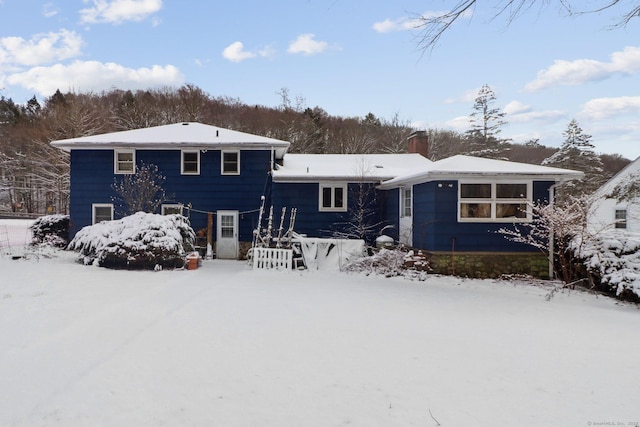 view of snow covered rear of property