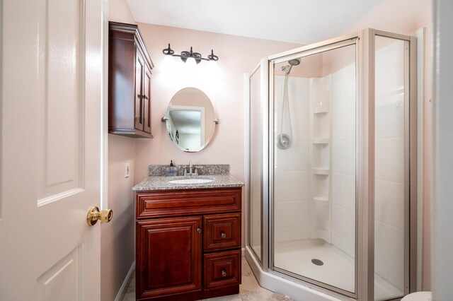 bathroom featuring an enclosed shower and vanity