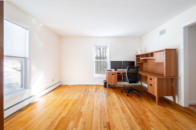 office space with baseboard heating and light hardwood / wood-style flooring