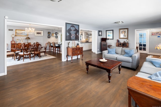 living room with dark hardwood / wood-style floors and a chandelier