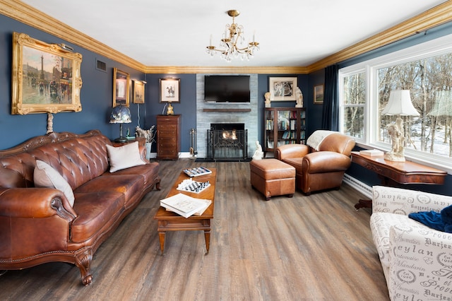 living room with hardwood / wood-style flooring, a fireplace, and ornamental molding