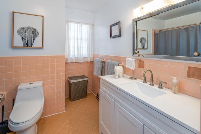 bathroom with tile walls, tile patterned flooring, vanity, walk in shower, and toilet