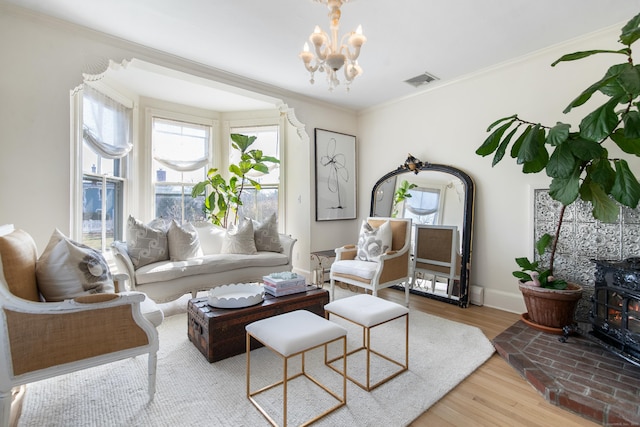 living room with crown molding, a chandelier, and light hardwood / wood-style floors