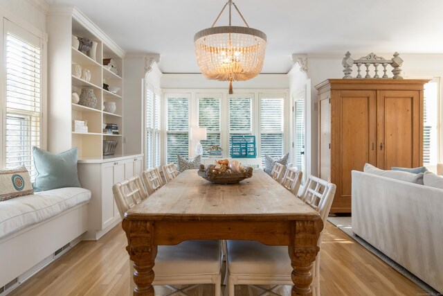 dining room featuring crown molding, light hardwood / wood-style flooring, and a chandelier