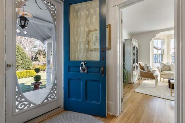 entryway featuring crown molding and light wood-type flooring