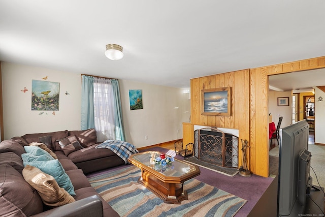 carpeted living room with wooden walls