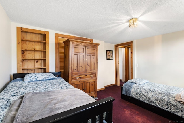 bedroom with dark colored carpet and a textured ceiling