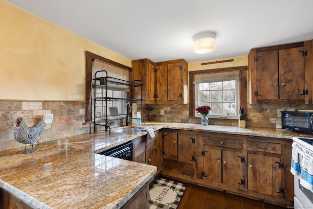 kitchen featuring sink, black appliances, kitchen peninsula, and dark hardwood / wood-style flooring