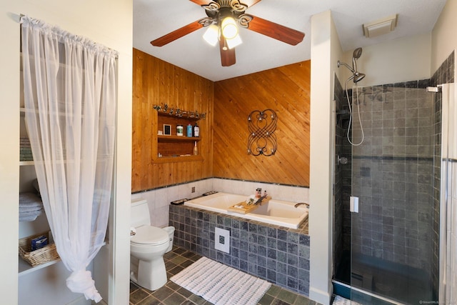 bathroom with tile patterned floors, ceiling fan, toilet, wood walls, and plus walk in shower