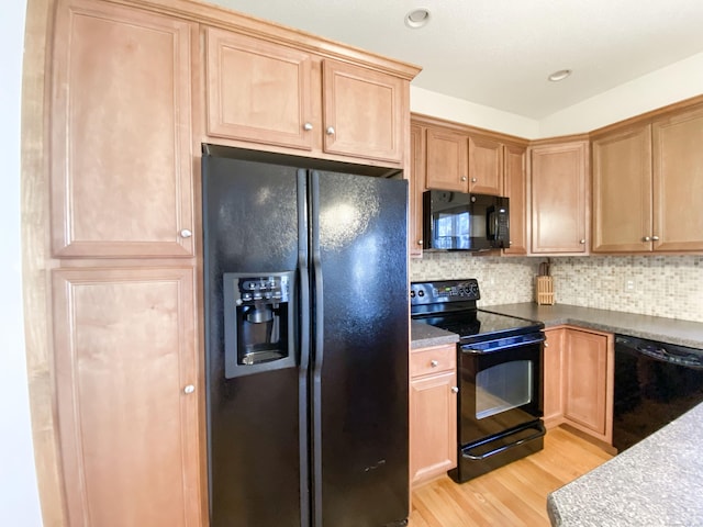 kitchen featuring decorative backsplash, black appliances, and light wood-type flooring