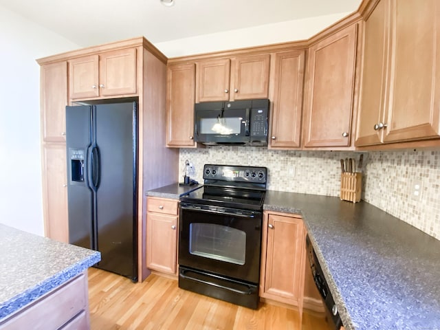 kitchen with light hardwood / wood-style floors, decorative backsplash, and black appliances