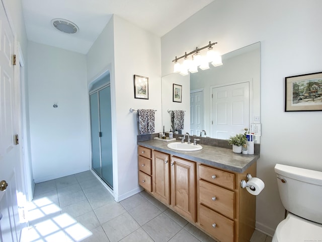 bathroom with tile patterned floors, vanity, toilet, and an enclosed shower