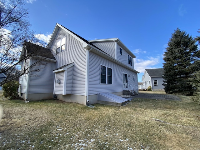 rear view of house featuring a lawn