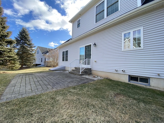 rear view of property featuring a patio area and a lawn