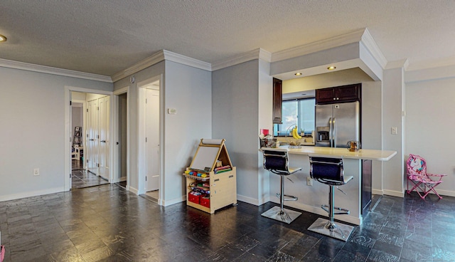 kitchen featuring a breakfast bar area, kitchen peninsula, a textured ceiling, and stainless steel fridge with ice dispenser