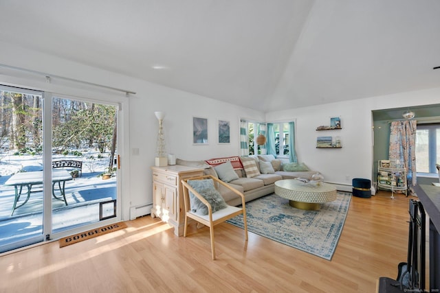 living room featuring a baseboard heating unit, vaulted ceiling, and light wood-type flooring