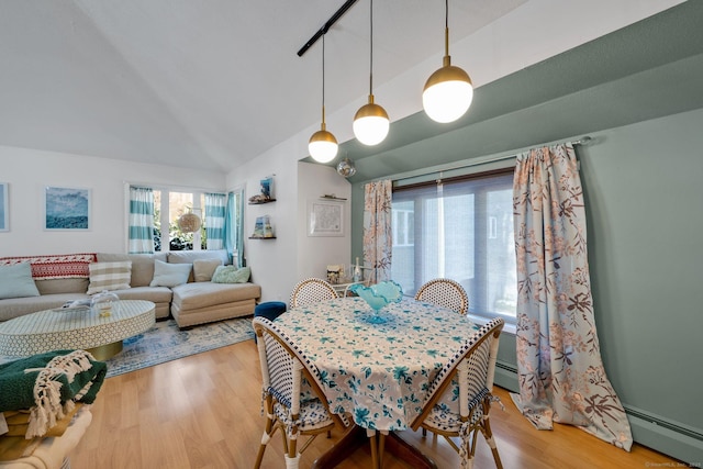 dining area featuring lofted ceiling, hardwood / wood-style floors, and baseboard heating