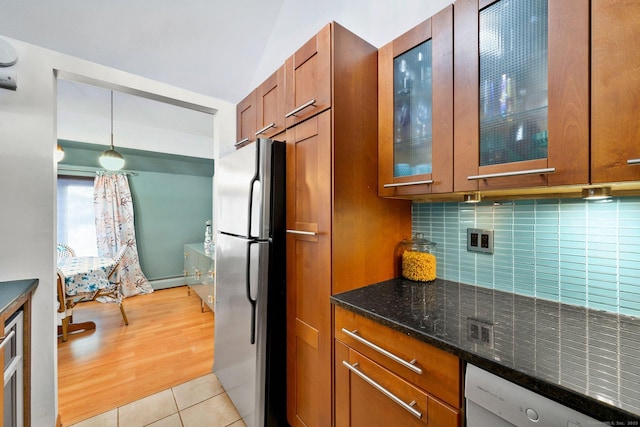 kitchen with tasteful backsplash, decorative light fixtures, light tile patterned floors, stainless steel fridge, and white dishwasher