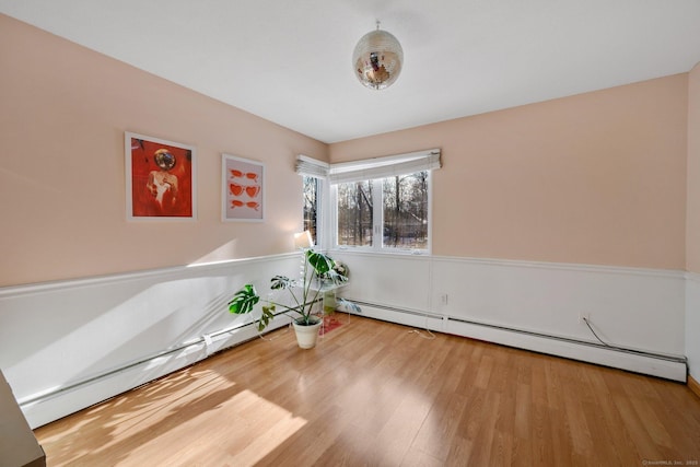 unfurnished room featuring a baseboard radiator and wood-type flooring