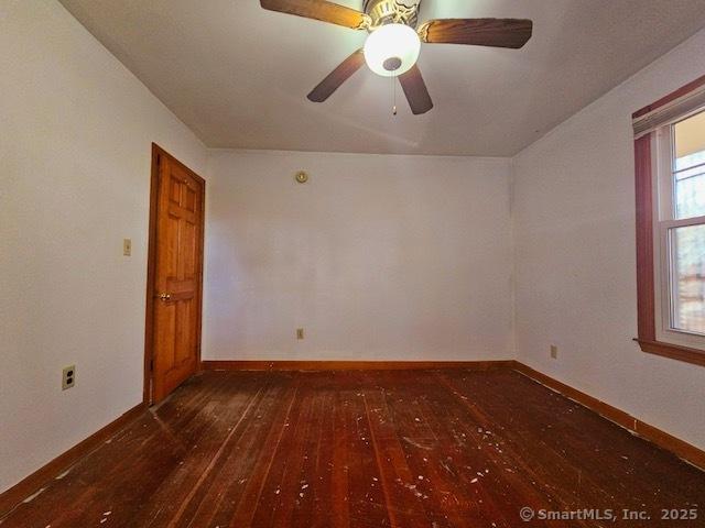 spare room featuring baseboards, wood-type flooring, and ceiling fan