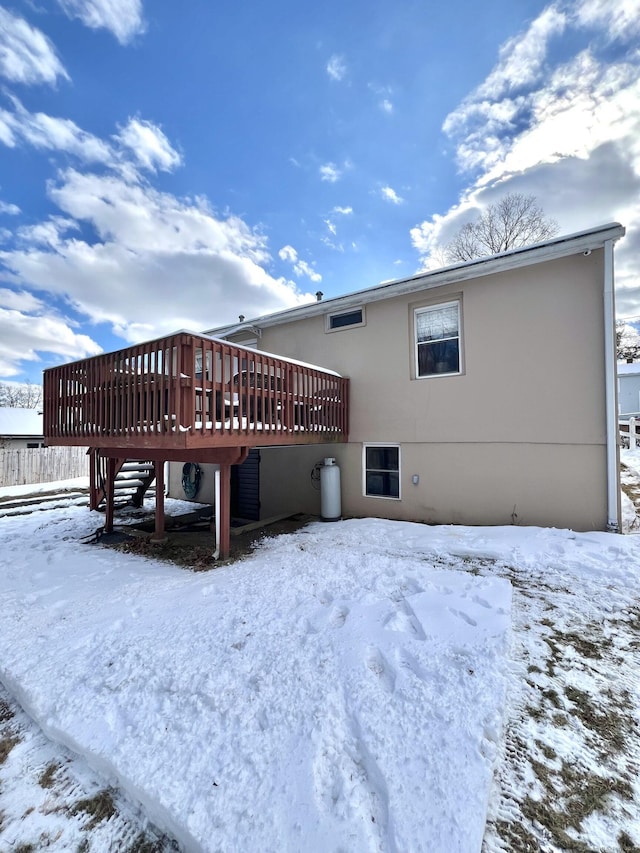 snow covered house with a deck