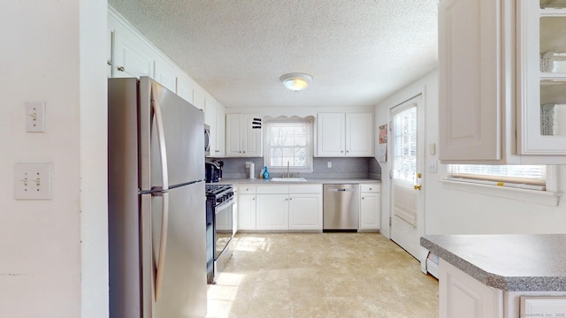 kitchen with sink, white cabinetry, appliances with stainless steel finishes, and a textured ceiling