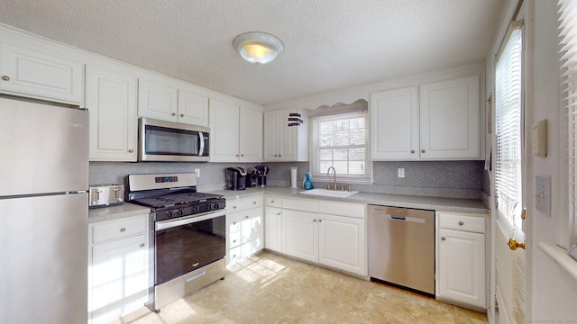 kitchen featuring sink, white cabinetry, appliances with stainless steel finishes, and a textured ceiling