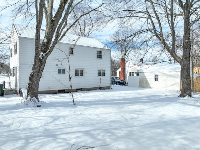 view of snow covered rear of property