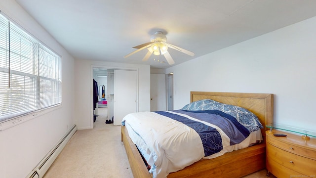 bedroom featuring a closet, ceiling fan, a baseboard radiator, and light carpet