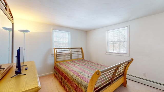 bedroom with light carpet and a baseboard radiator