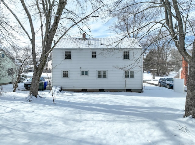 view of snow covered rear of property