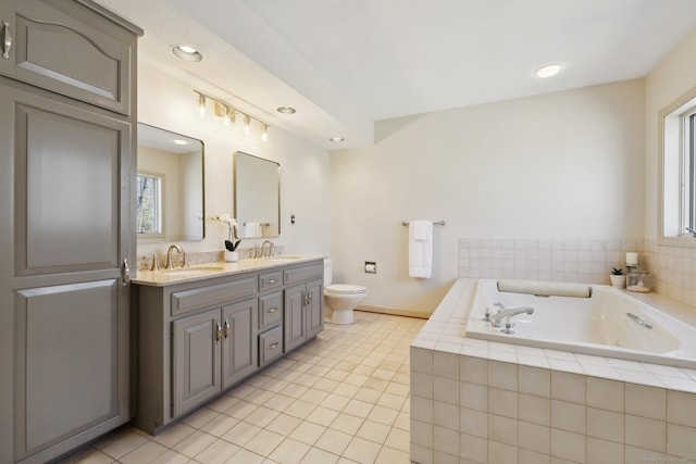 full bathroom featuring tile patterned flooring, double vanity, toilet, a sink, and a garden tub