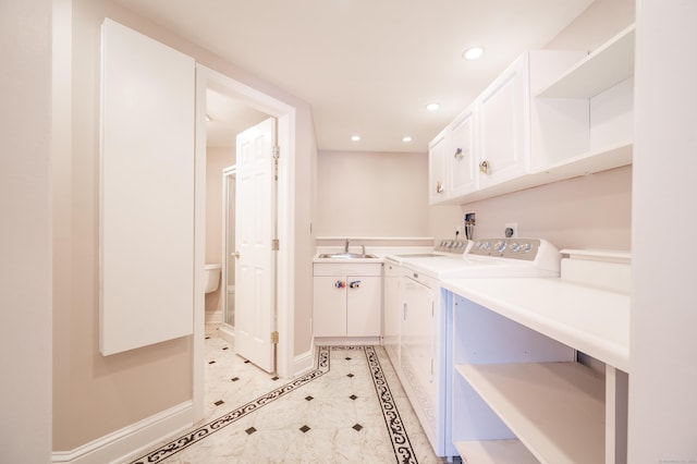 laundry room featuring cabinets, light tile patterned floors, sink, and washing machine and clothes dryer