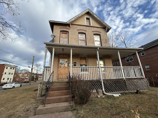 view of front of home with a porch and a front yard