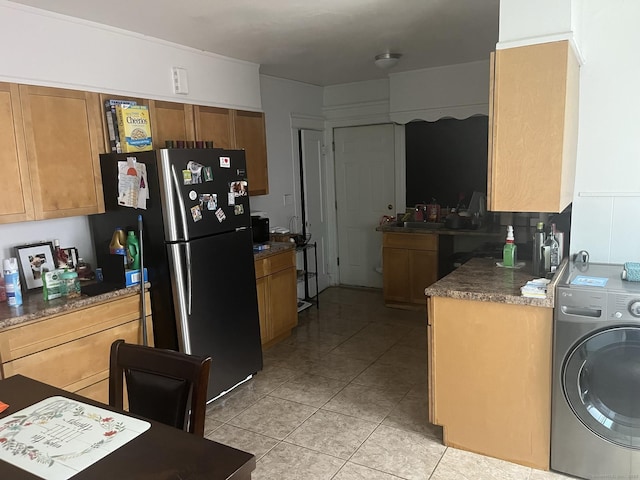 kitchen featuring washer / clothes dryer, light tile patterned flooring, and stainless steel fridge