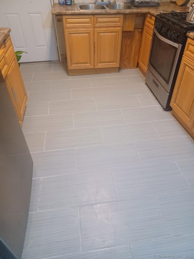 kitchen with gas range, sink, and light tile patterned floors