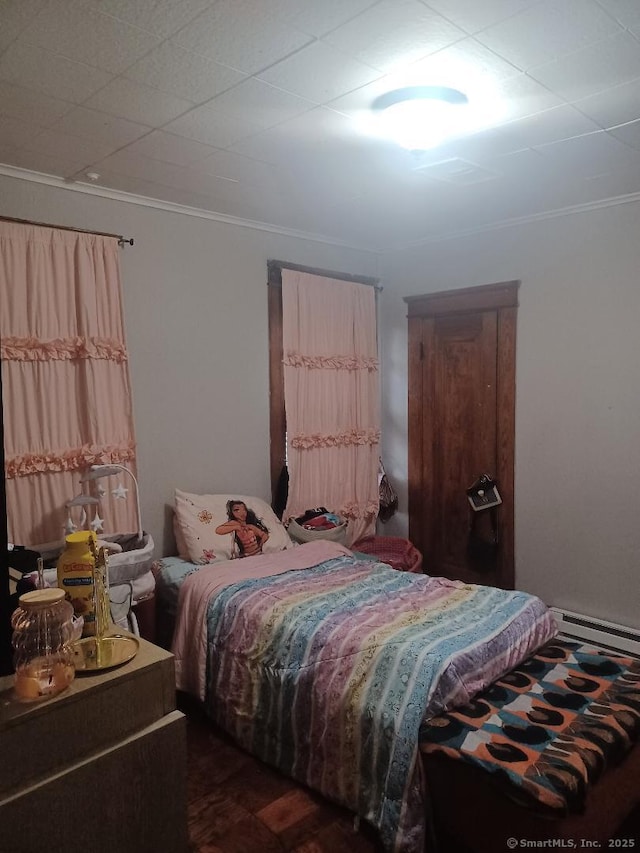 bedroom with a baseboard heating unit and ornamental molding