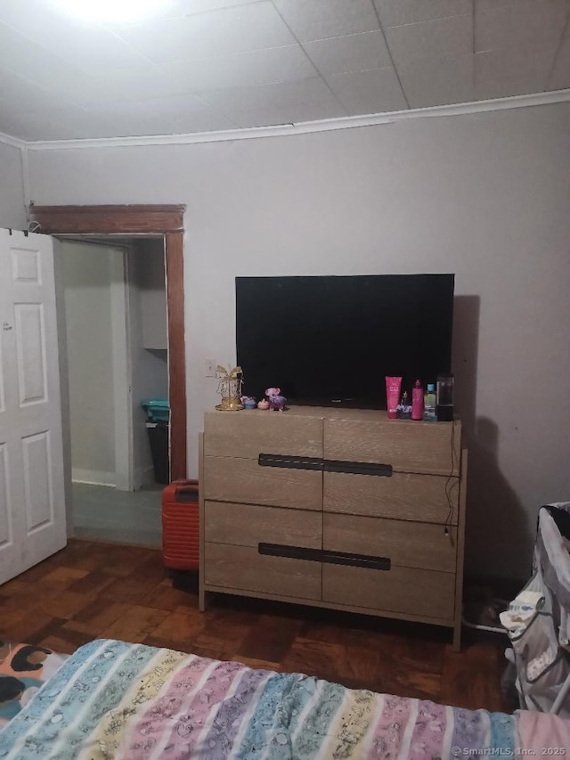 bedroom featuring crown molding and dark hardwood / wood-style floors